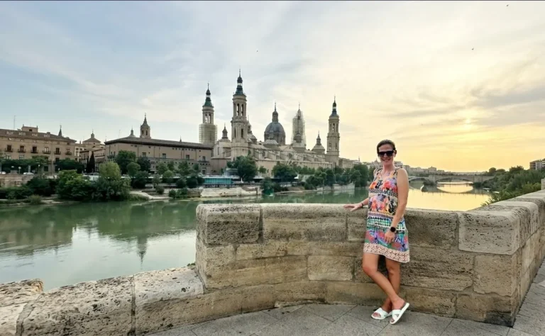 A traveler posing on Stone Bridge with Ebro River and Basilica del Pilar background in Zaragoza, Spain