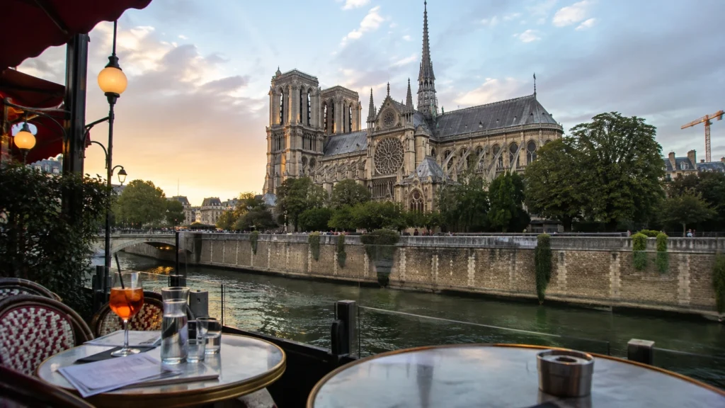 Sunset view of Notre-Dame Cathedral from a Left Bank café terrace in Paris