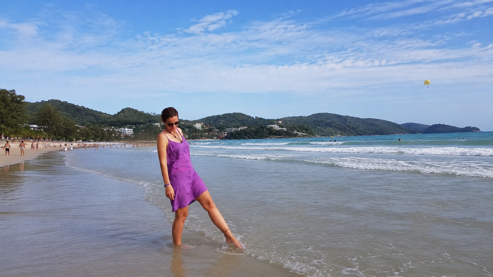 Phuket travel guide: walking along Patong Beach with a parasail in the distance