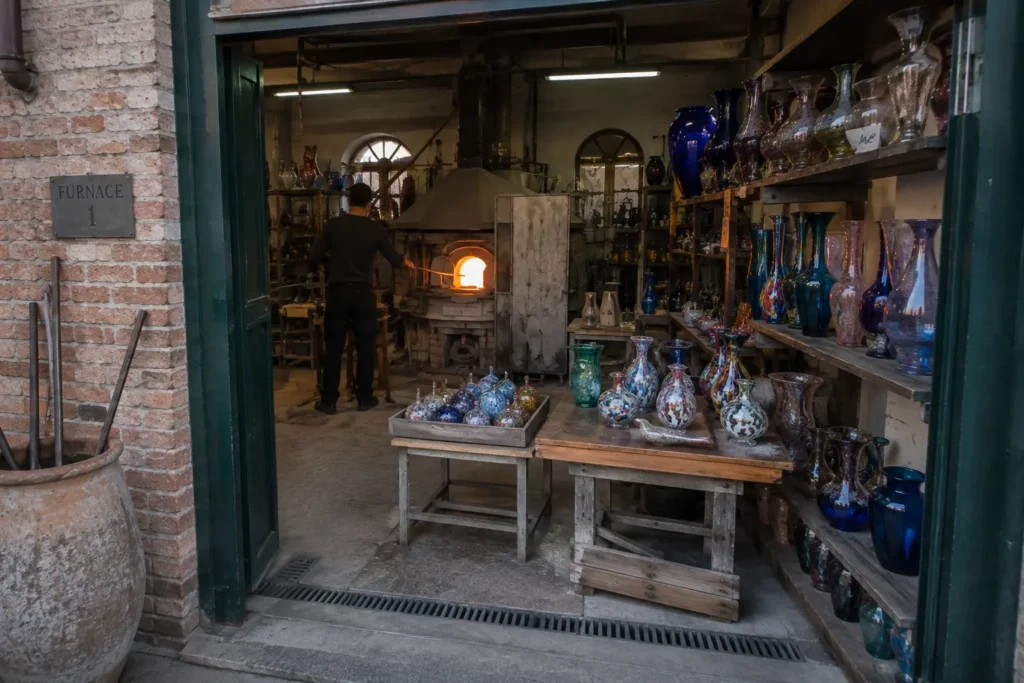 Glassblower shaping molten glass in a Murano workshop