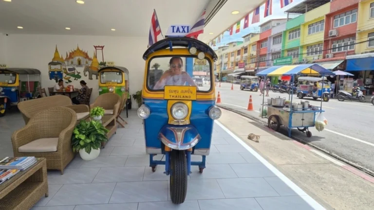 A traditional tuk-tuk driving through the busy streets of Bangkok, Thailand, surrounded by colorful lights and city traffic.
