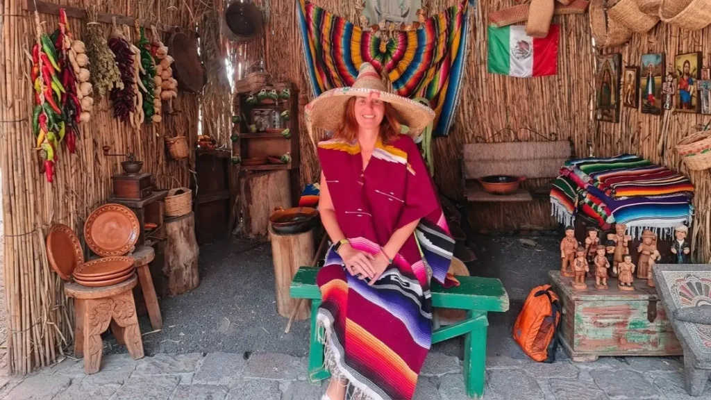 Mabel, founder of solo travel blog GoTravelica, sitting in a Mexican hat and traditional outfit