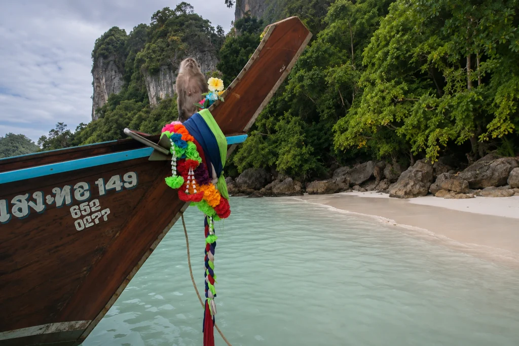 Long-tail boat with a monkey on the bow near Phi Phi Islands