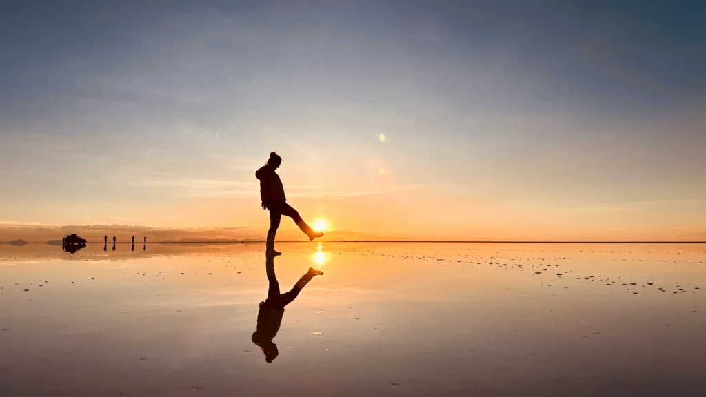 silhouette walking on the Salar de Uyuni mirror at sunset