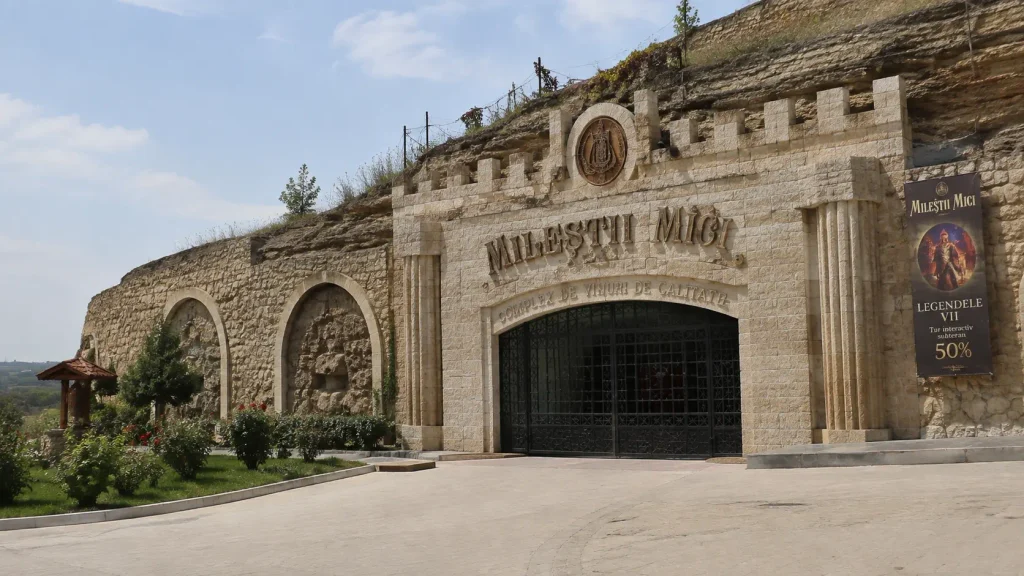 Milestii Mici wine cellars carved limestone entrance with ornate stone archway and dark wooden doors, UNESCO World Heritage wine site