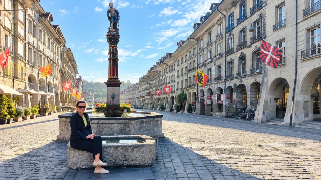 A historic fountain on a flag-lined street in Bern's arcaded Old Town
