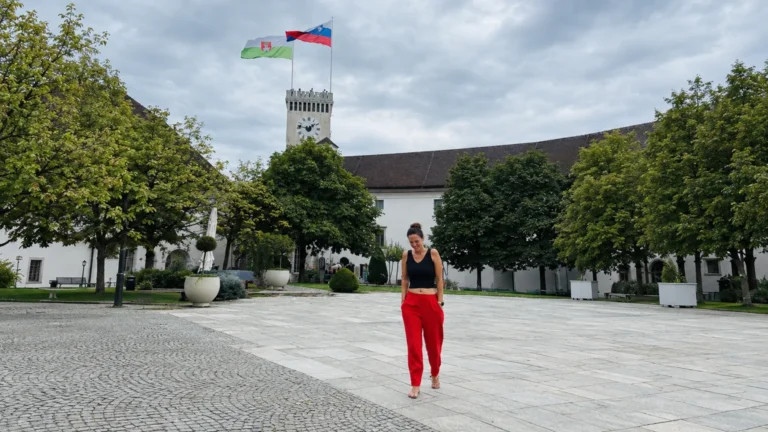 Ljubljana travel guide cover photo of the castle courtyard and clock tower with the Slovenian flag