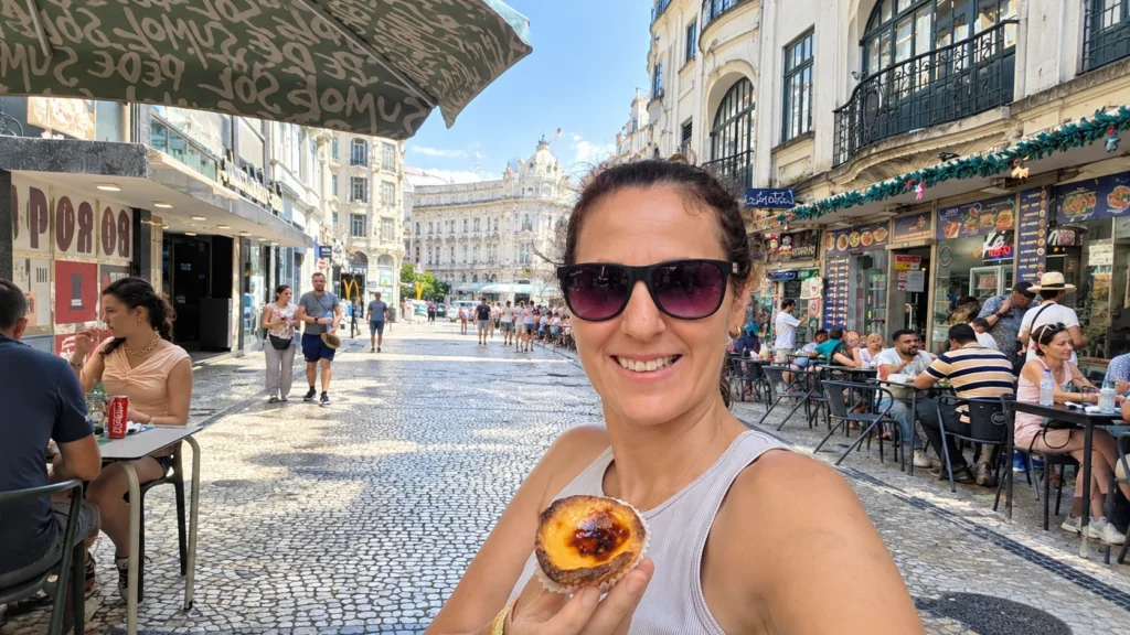 Eating a pastel de nata on a Porto travel guide stop in the city center