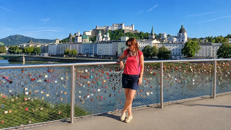Salzburg travel guide cover with Hohensalzburg Fortress and the Old Town skyline seen from a love-lock bridge over the Salzach River
