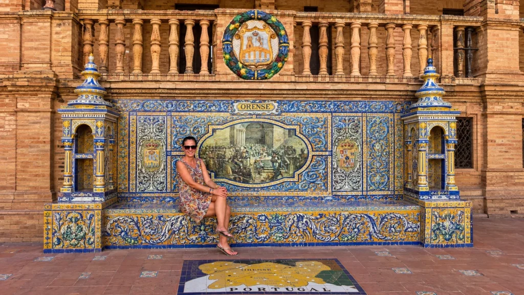Visitor sitting on one of Plaza de España's tiled provincial benches in Seville