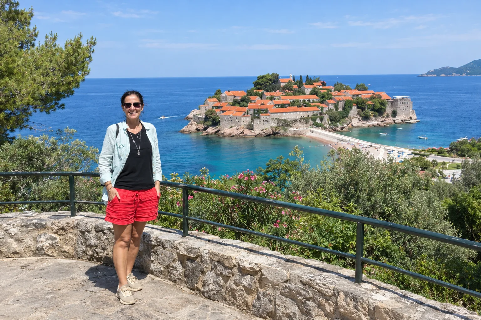 Budva travel guide: traveler at the Sveti Stefan viewpoint with the island and Adriatic Sea behind