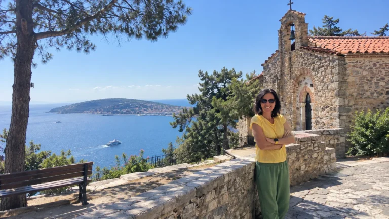 Buyukada travel guide cover: woman standing by the stone Aya Yorgi church with the Marmara Sea and another Princes’ Island behind
